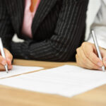 Businesswoman,And,Businessman,Signing,Contract,In,The,Office