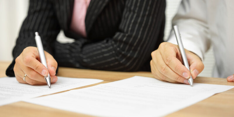 Businesswoman,And,Businessman,Signing,Contract,In,The,Office